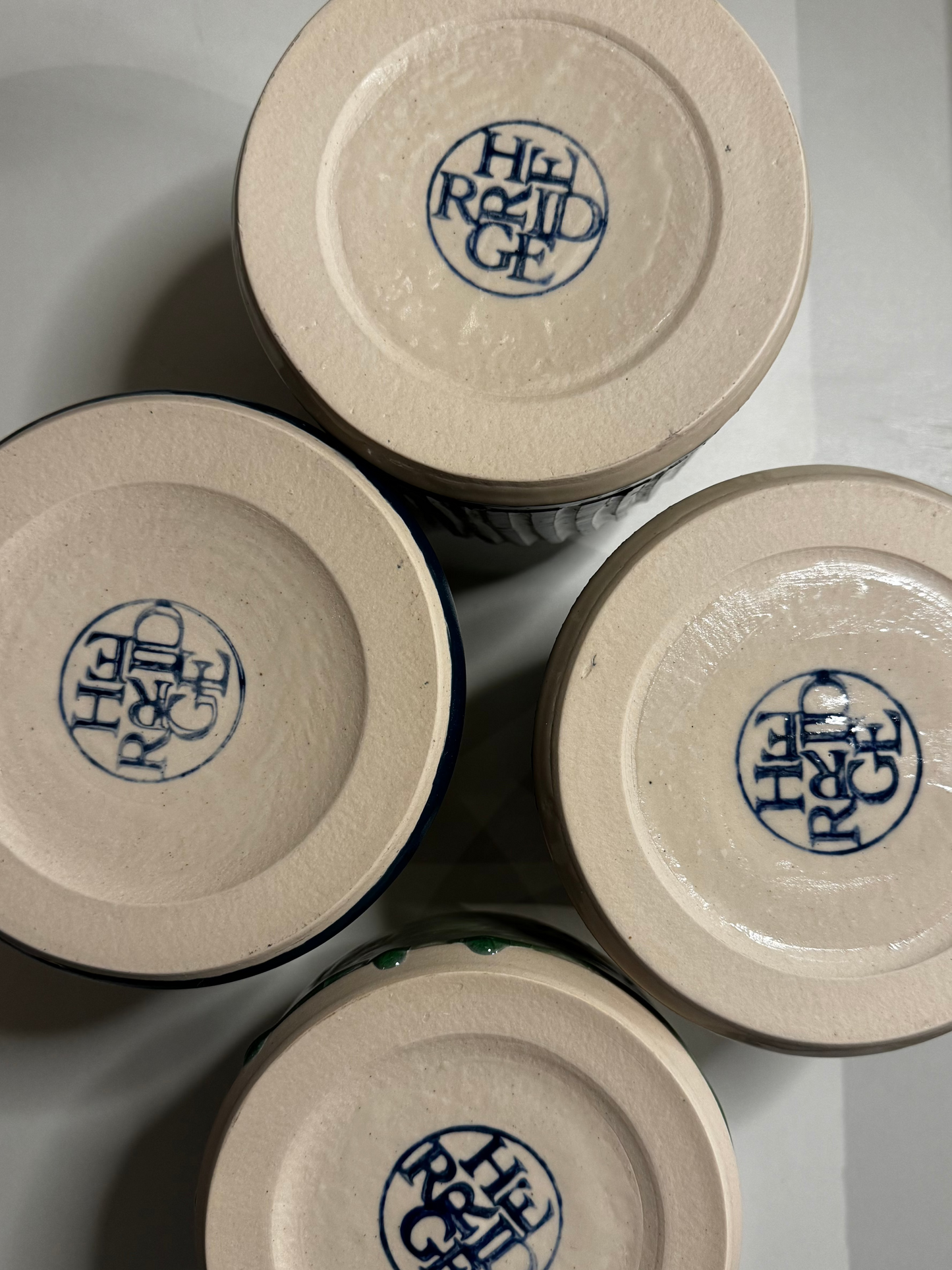 Bottom of four vases showing the carved, glazed Herridge Pottery logo stamp.
