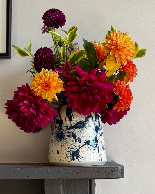 Blue splatter Herridge Pottery Vase with bunch rich coloured dahlias.