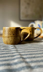 Handmade ceramic amber mug from herridge pottery - on table