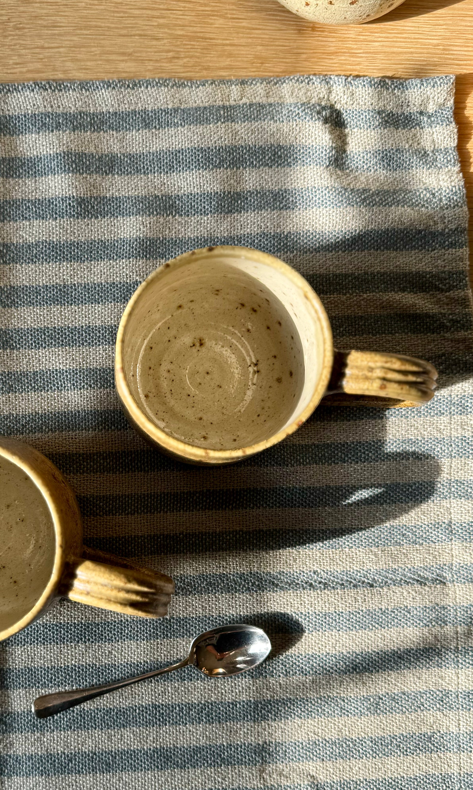 Handmade ceramic amber mug from herridge pottery - on table top