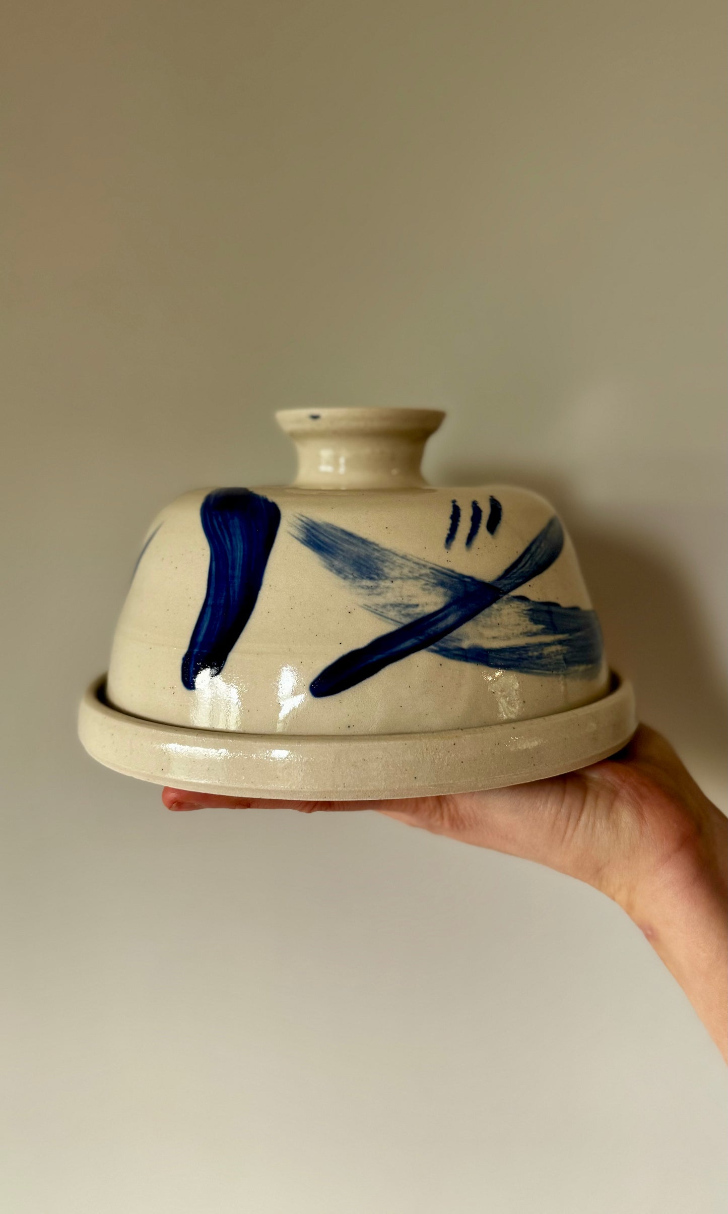 Handmade ceramic butter dish by Herridge Pottery in Blue Swoosh held