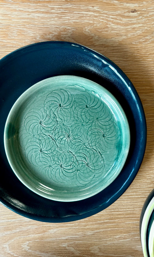 Handmade ceramic decorative plate from Herridge Pottery in deep green with spiral surface texture..