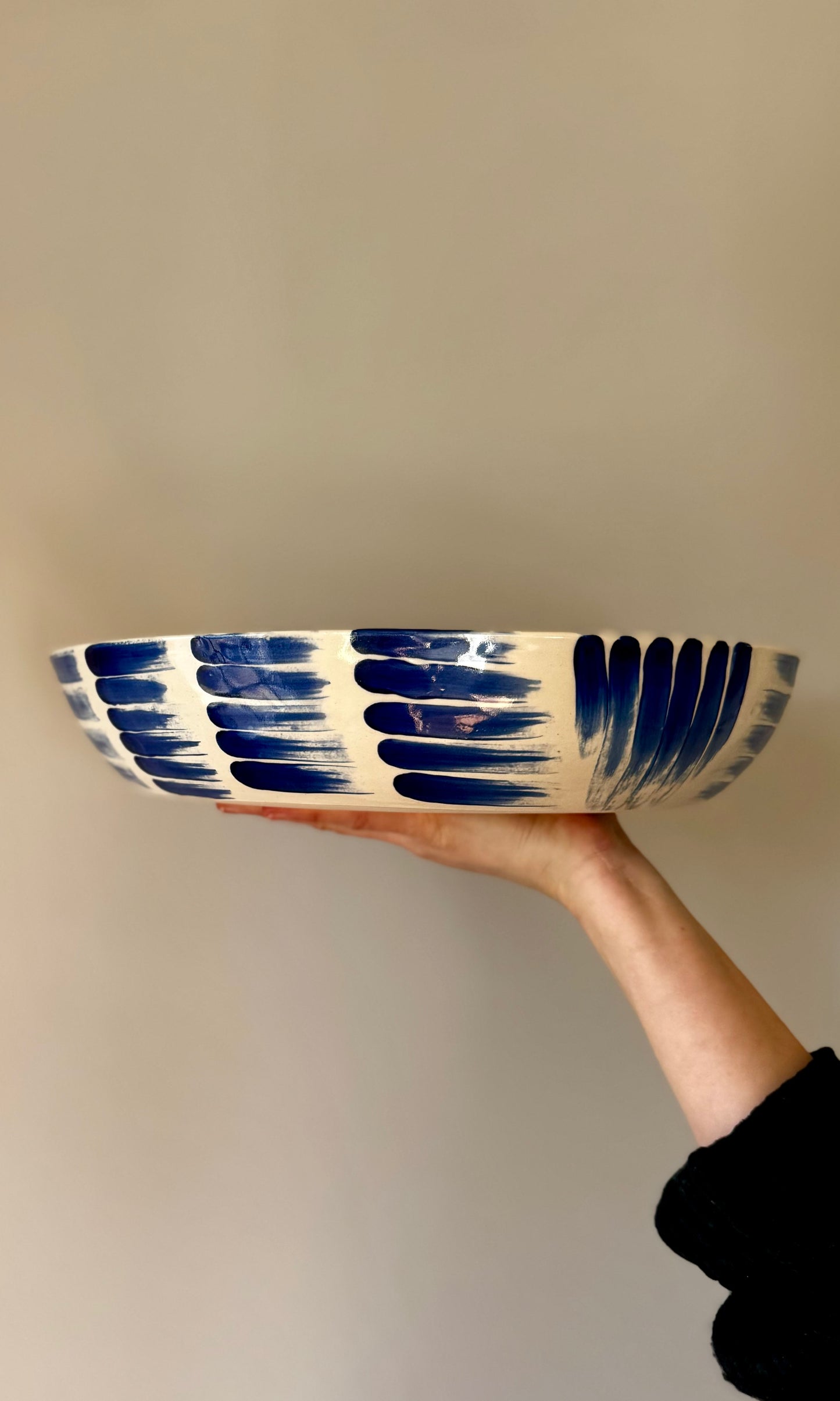 Handmade ceramic extra large feasting bowl with blue splodges by Herridge Pottery - held side