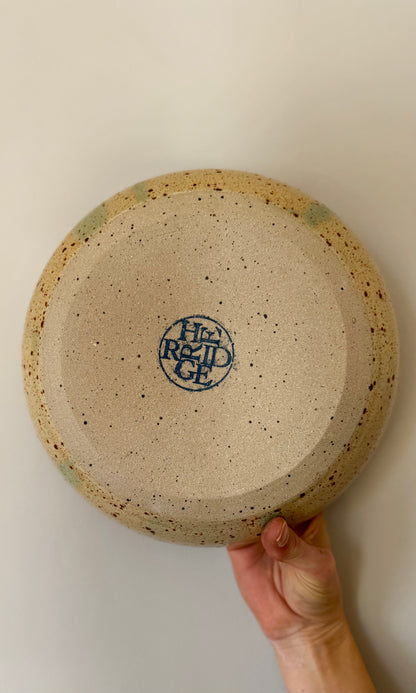 Handmade ceramic feasting bowl in celadon green from Herridge Potter - held bottom