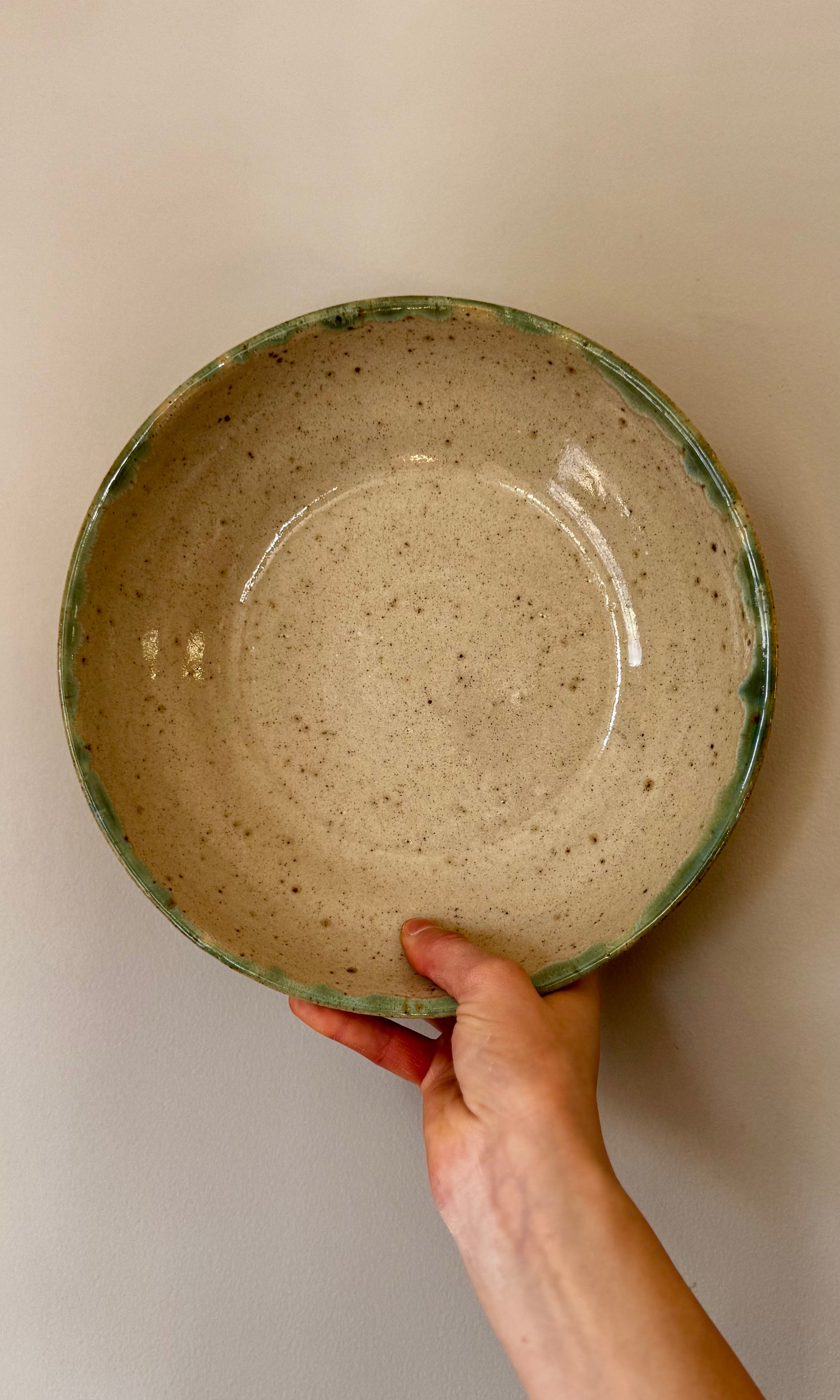 Handmade ceramic feasting bowl in celadon green from Herridge Potter - held top