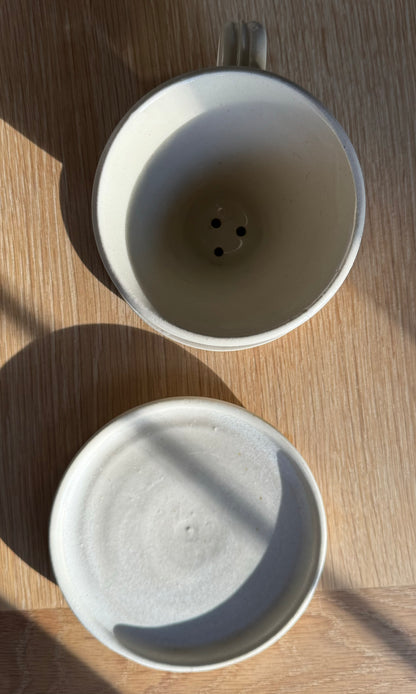 Handmade oatmeal coloured ceramic coffee pour-over from above. Saucer and pour-over separated. Made by Herridge Pottery.