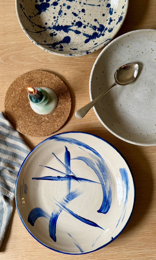 Ceramic plates with blue abstract designs on a wooden table.