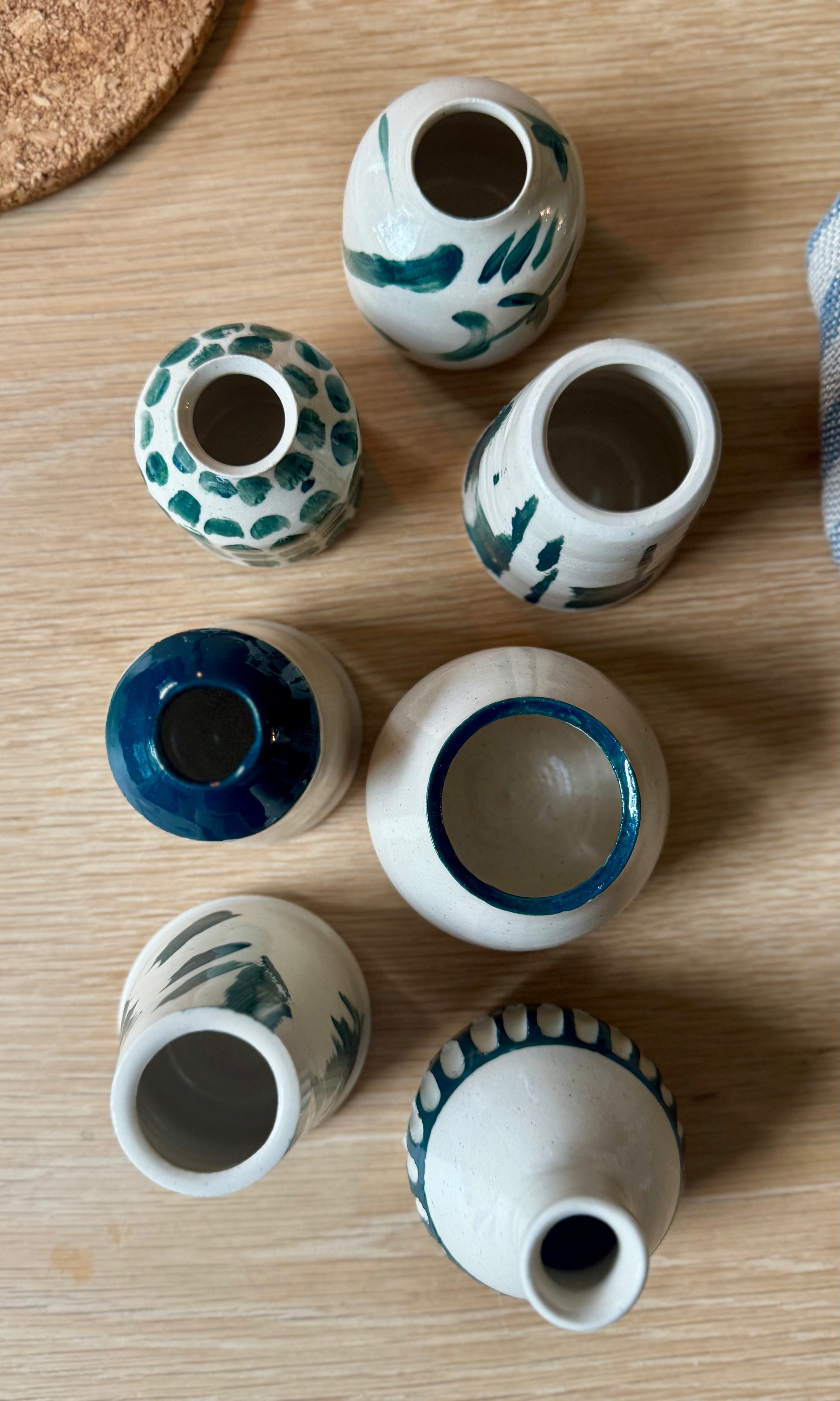 Set of small ceramic pots with decorative patterns on a wooden surface