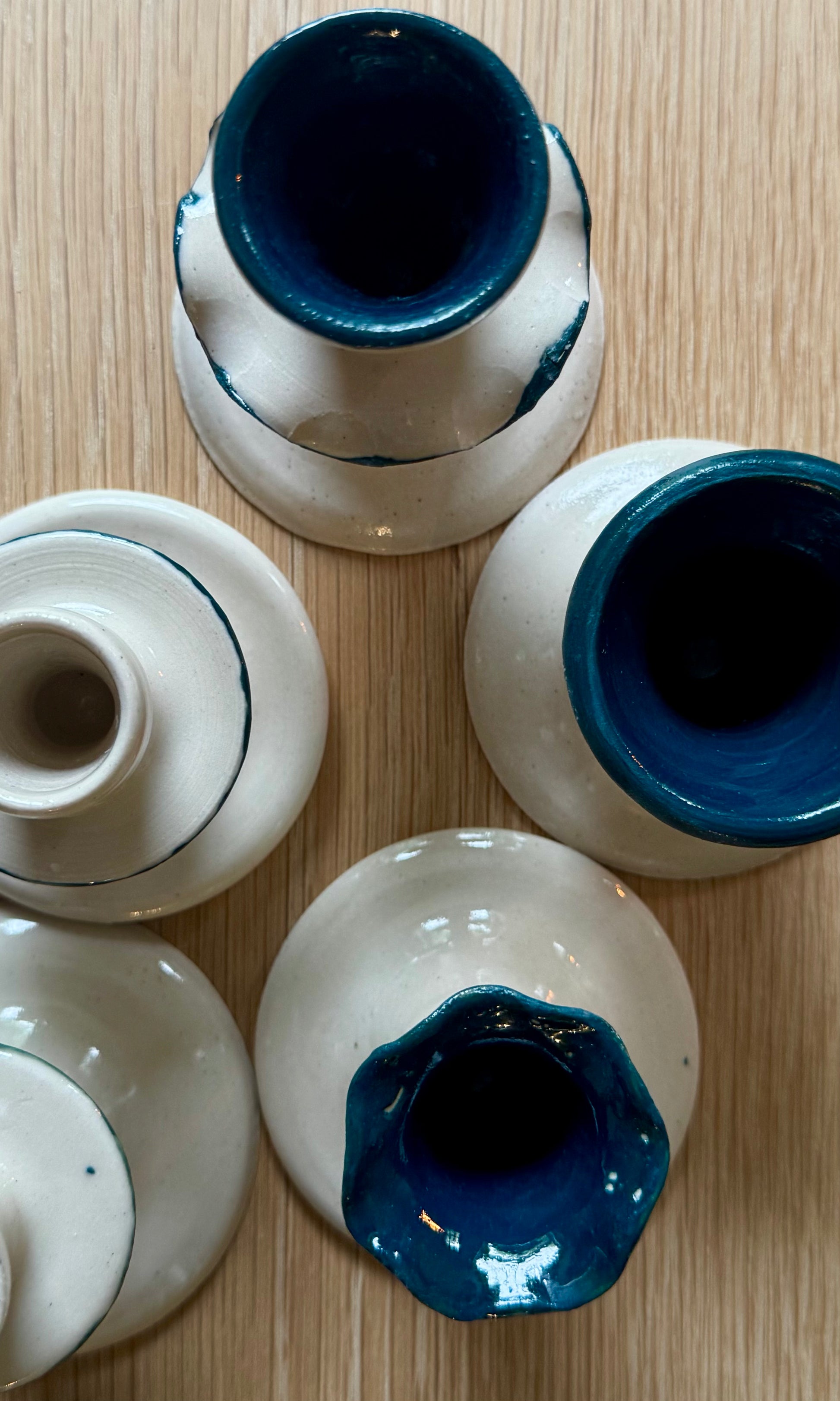 Set of ceramic candle stick holders with blue and white design on a wooden surface